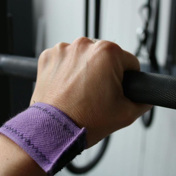 Details of hands gripping a heavy metal barbell.
